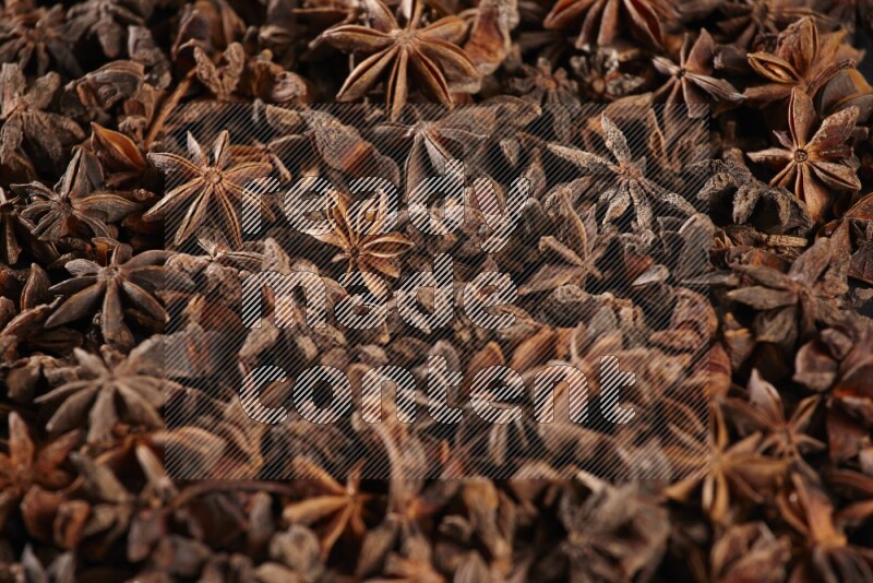 Star Anise herbs fill the frame on black flooring