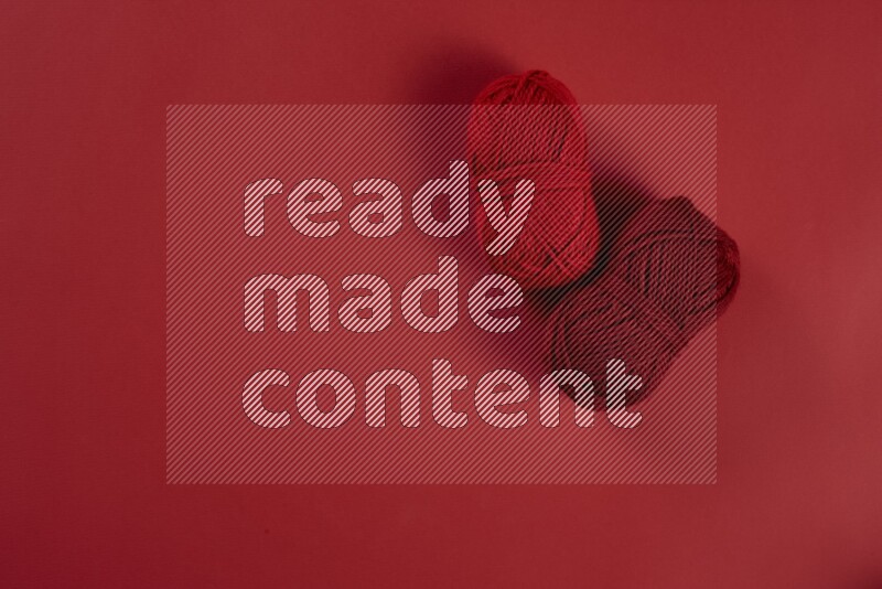 A red collection of sewing and tailoring tools arranged on a red background