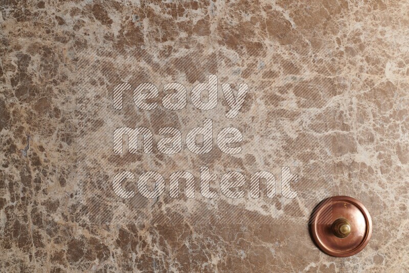 A small copper pot on beige marble background