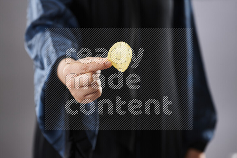 امرأة ترتدي عباءة تحمل أنواع مختلفة من الوجبات الخفيفة في أوضاع متعددة