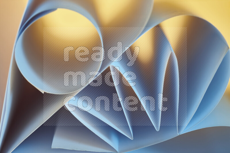 An artistic display of paper folds creating a harmonious blend of geometric shapes, highlighted by soft lighting in blue and warm tones
