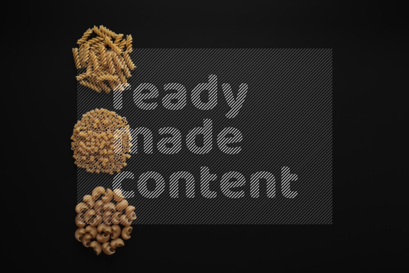 Different pasta types in 3 bunches on black background