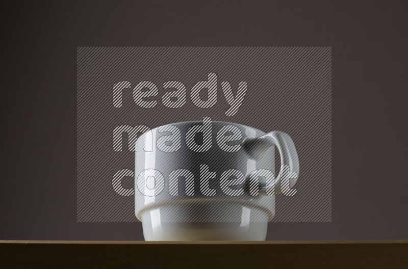 Low angle shot of a white cup on grey background