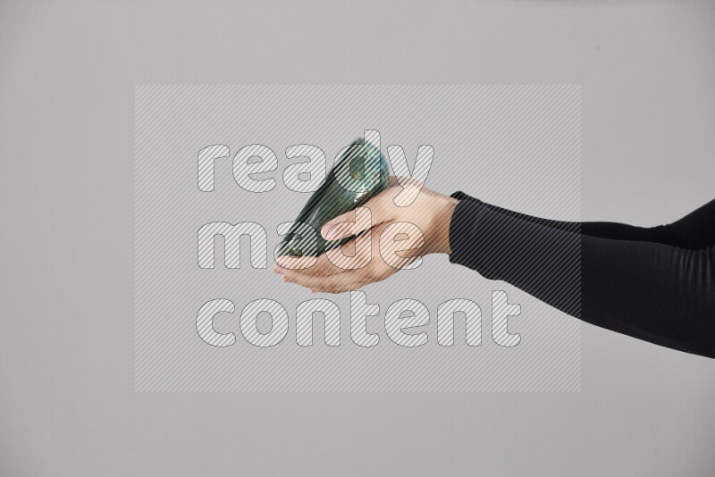 A woman in black abaya holding different pottery essentials in different positions