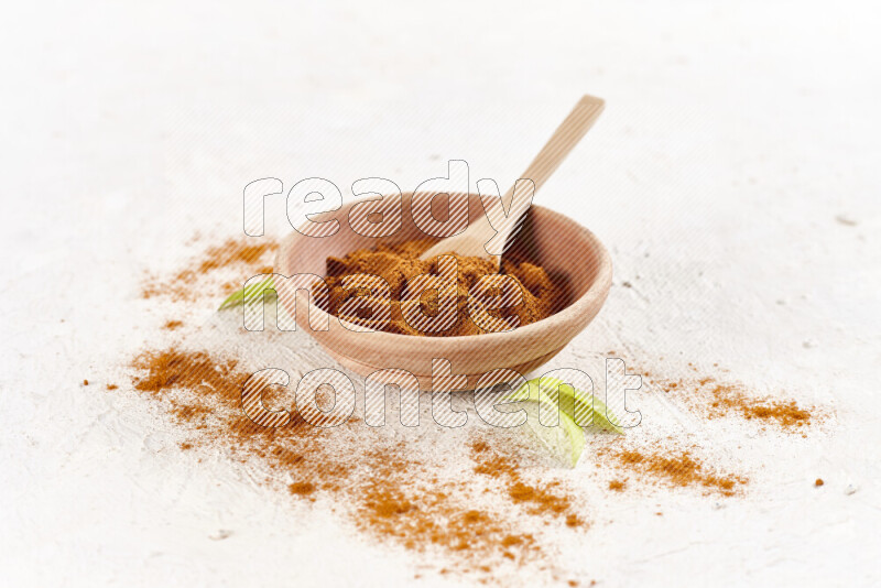 A wooden bowl full of ground paprika powder on white background
