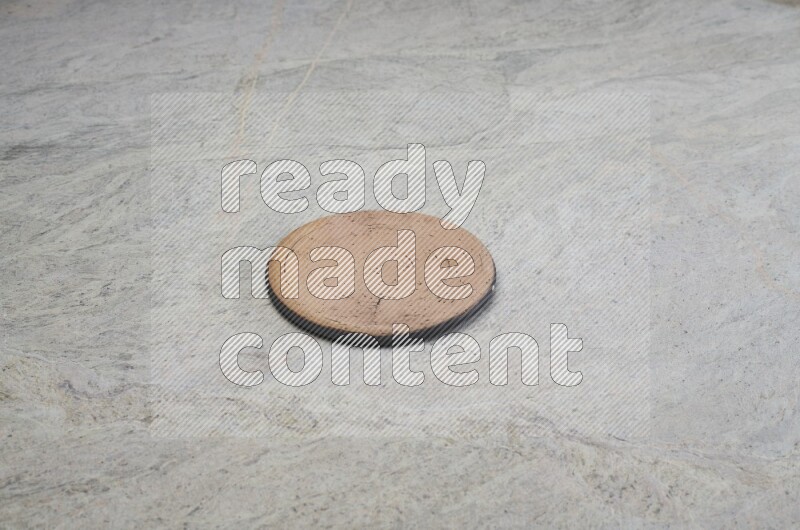 A flat pottery plate on grey marble background