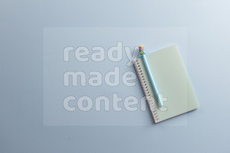 A blue notebook with different school supplies on blue background