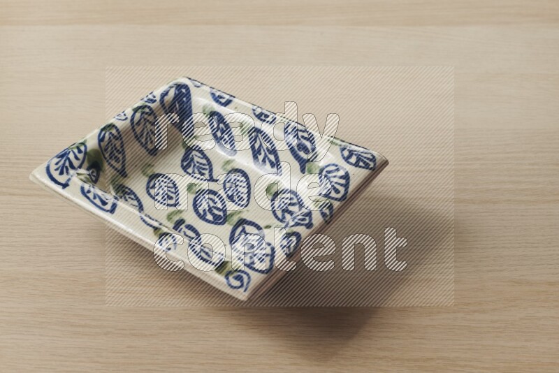 A decorative pottery plate on light wooden background