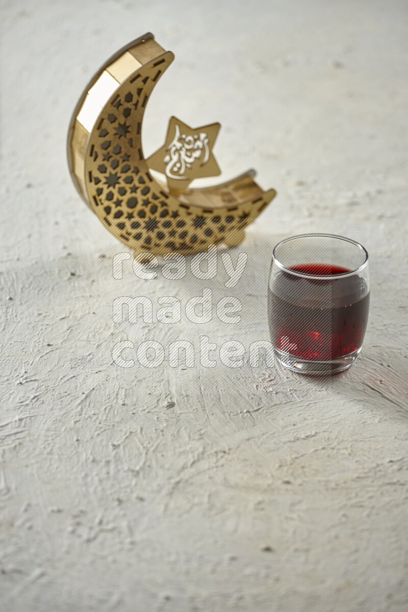A wooden golden crescent lantern with different drinks, dates, nuts, prayer beads and quran on white background