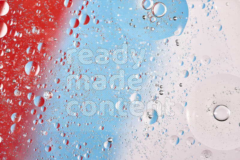 Close-ups of abstract oil bubbles on water surface in shades of red, white and blue