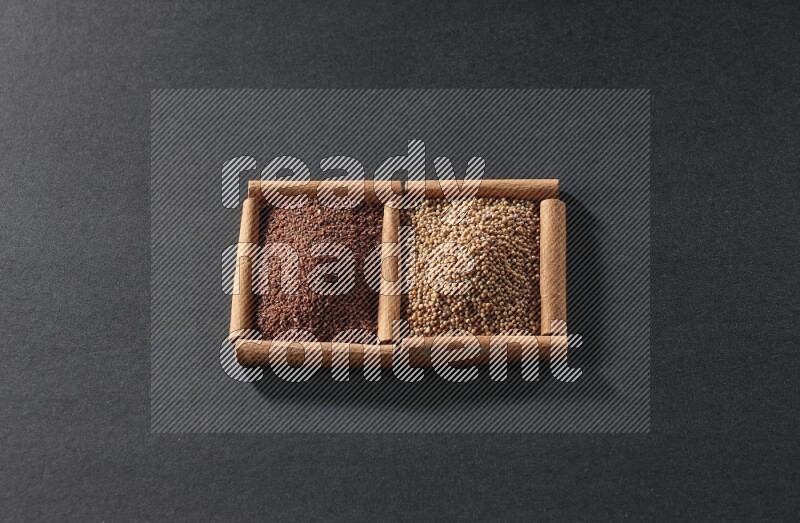 مربعان من أعواد القرفة ممتلئان بحبوب الخردل وحب الرشاد علي خلفية سوداء