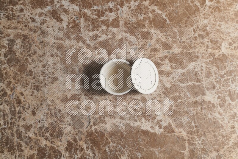A pottery cup on beige marble background