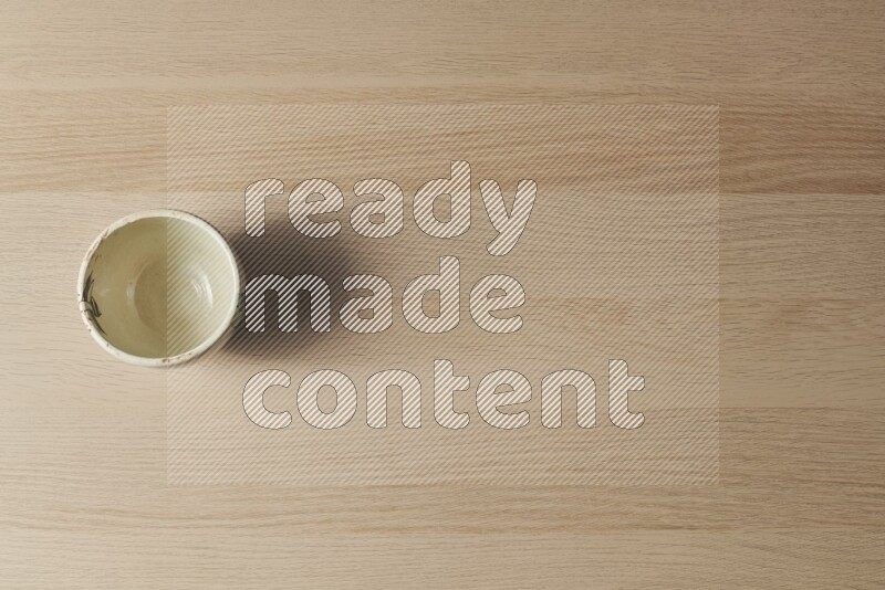 A white pottery bowl on light wooden background