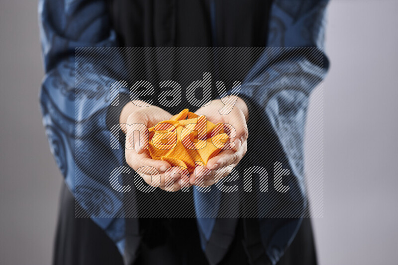 Woman in abaya holding different kinds of snacks in different positions