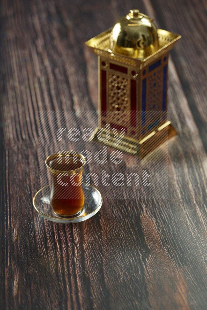 A golden lantern with different drinks, dates, nuts, prayer beads and quran on brown wooden background