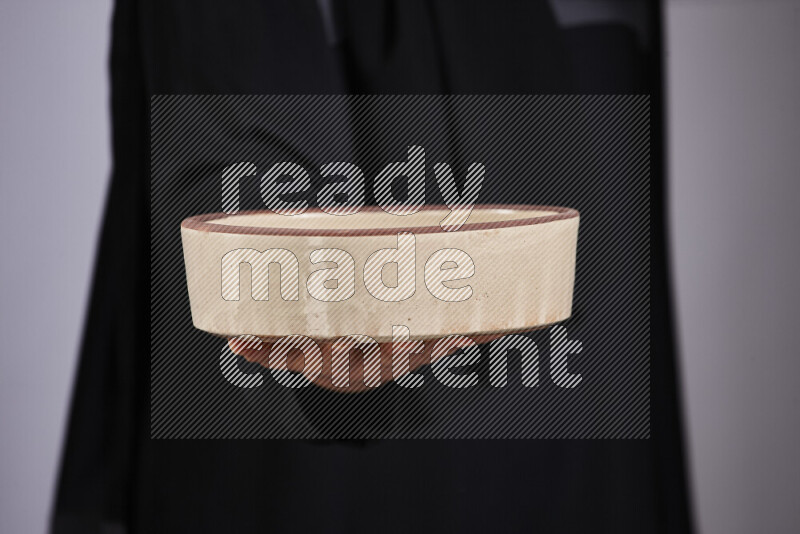 امرأة ترتدي عباءة سوداء تحمل أدوات فخارية مختلفة في أوضاع متعددة