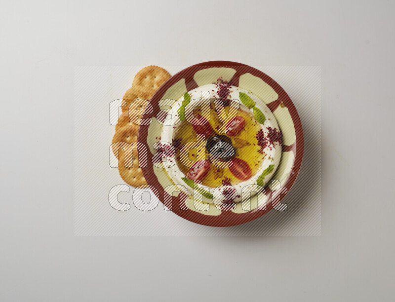Lebnah garnished with Cherry tomato, mint & sumak  in a traditional plate on a white background