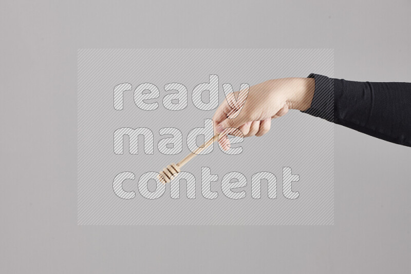 امرأة ترتدي عباءة سوداء تحمل أدوات خشبية مختلفة في أوضاع متعددة