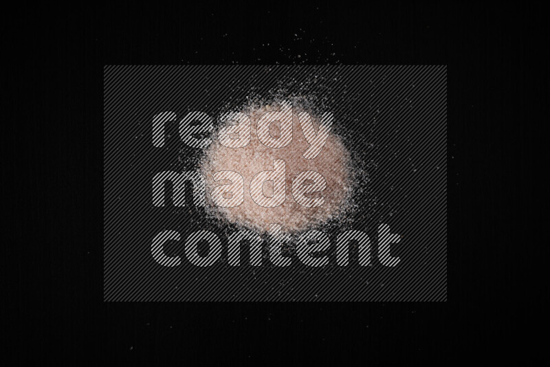 A bunch of fine himalayan pink salt on black background