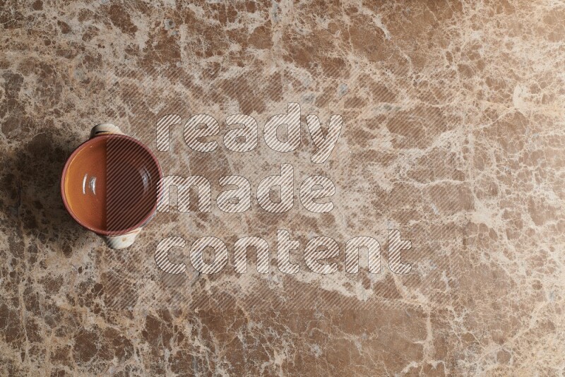 A multicolored pottery pot on beige marble background