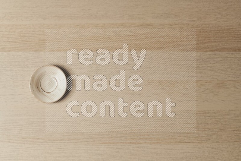 A pottery coaster on light wooden background