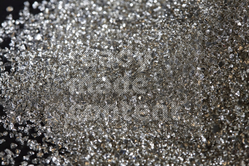 قطع زجاجية فضية لامعة متناثرة على خلفية سوداء