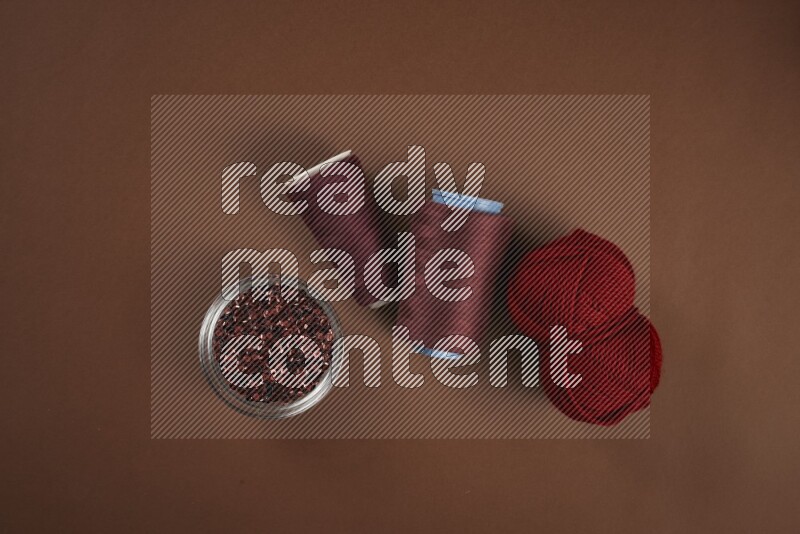 A red collection of sewing and tailoring tools arranged on a brown background