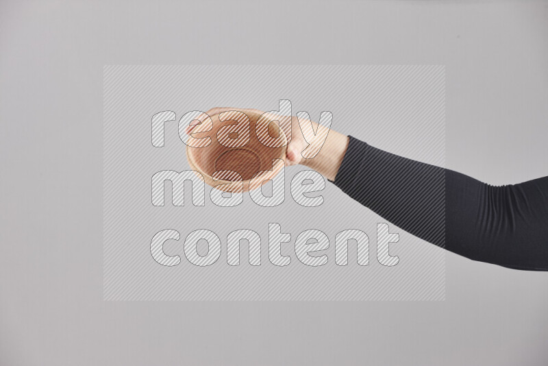 امرأة ترتدي عباءة سوداء تحمل أدوات خشبية مختلفة في أوضاع متعددة