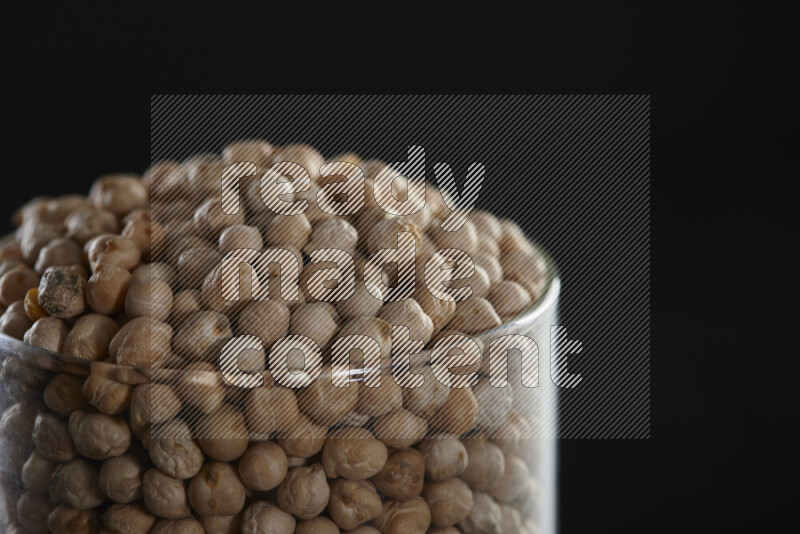 Chickpeas in a glass jar on black background