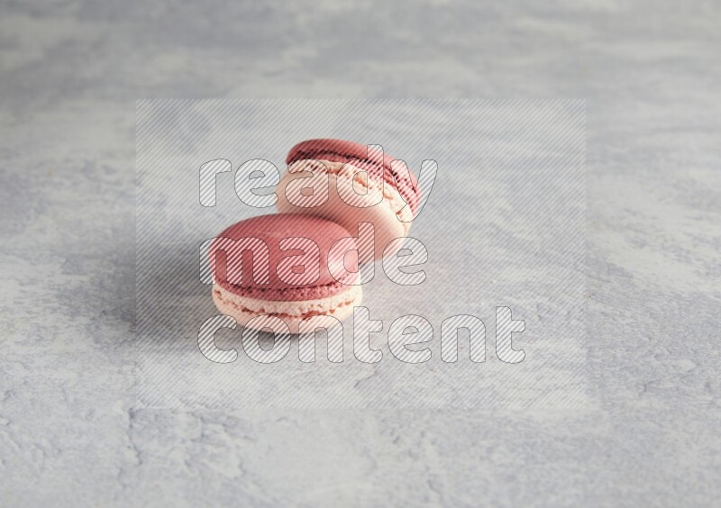 45º Shot of two Pink Litchi Raspberry macarons  on white  marble background