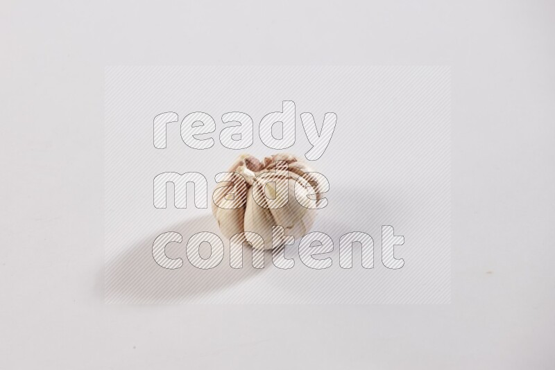 A whole garlic bulb placed on a white flooring