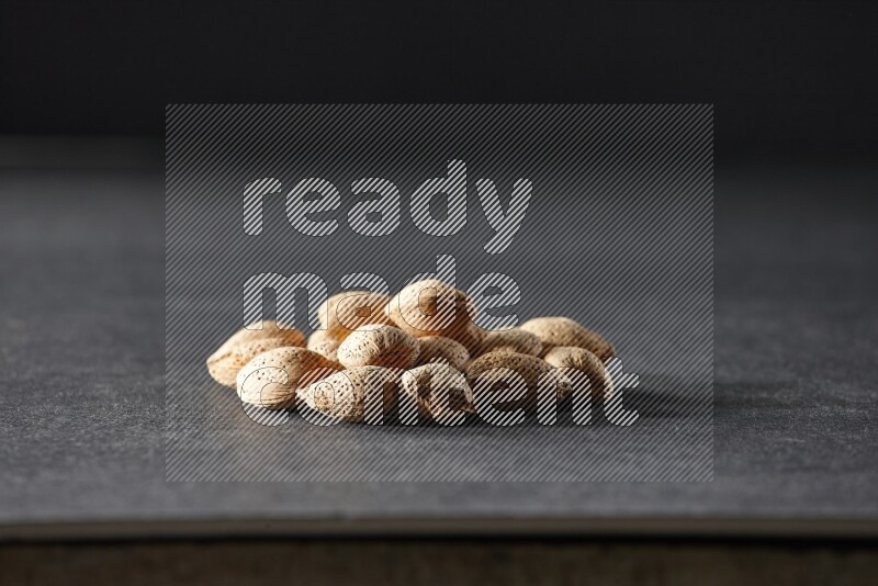 A bunch of almonds on a black background in different angles
