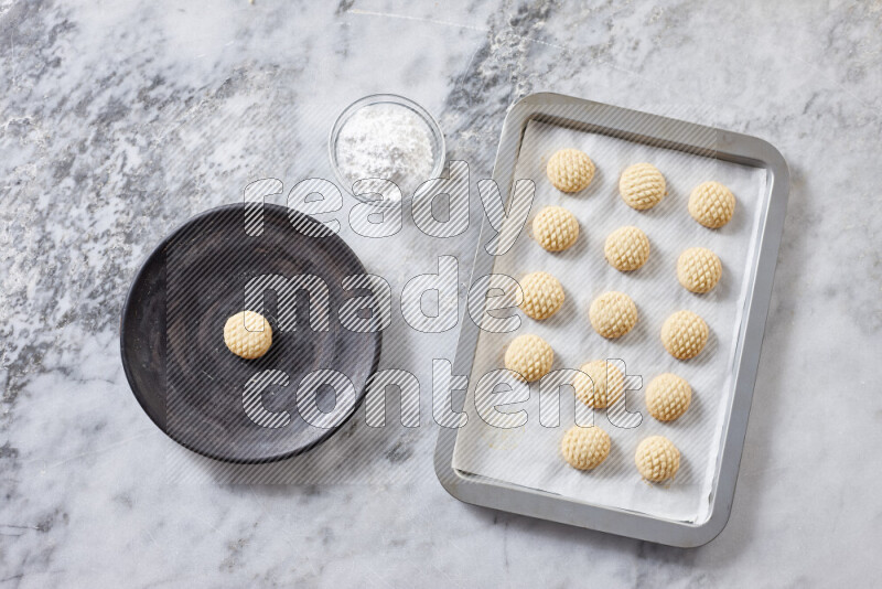 Kahk step by step with its ingredients ghee, sugar, flour, sesame, yeast, water and kahk flavor on grey marble background