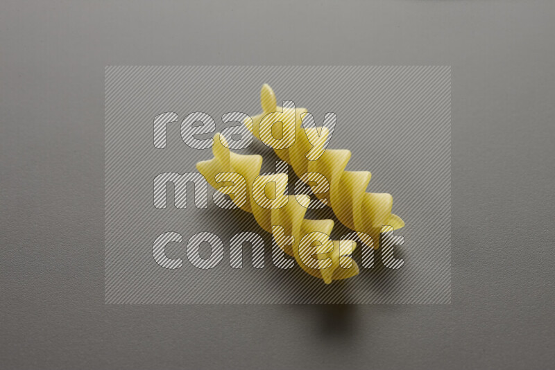 Fusilli pasta on grey background