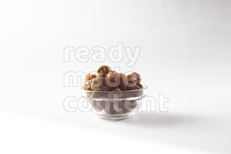 Dates in a glass bowl on white background