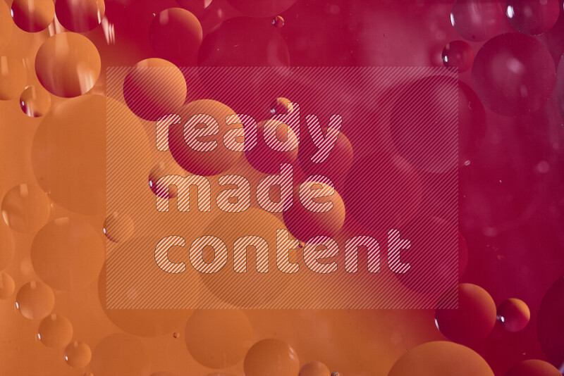Close-ups of abstract oil bubbles on water surface in shades of red and orange