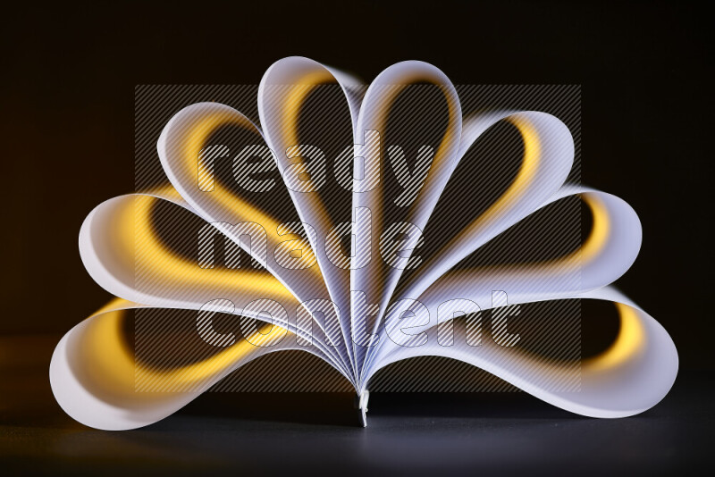 An abstract art piece displaying smooth curves in yellow and white gradients created by colored light