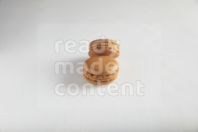 45º Shot of of two assorted Brown Irish Cream, and Brown Maple Taffy macarons  on white background