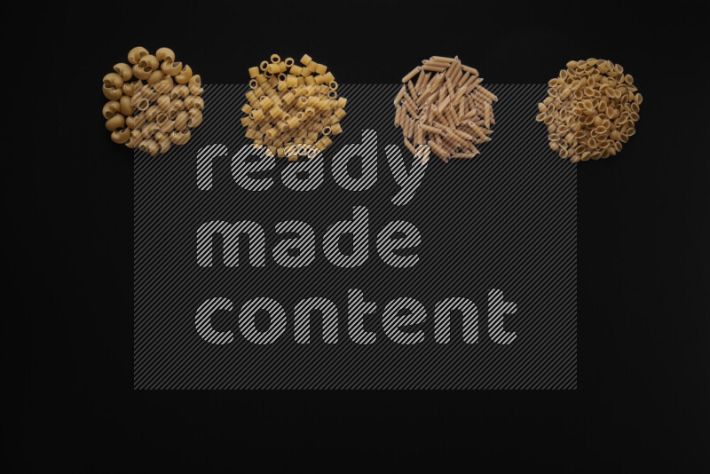 Different pasta types in 4 bunches on black background