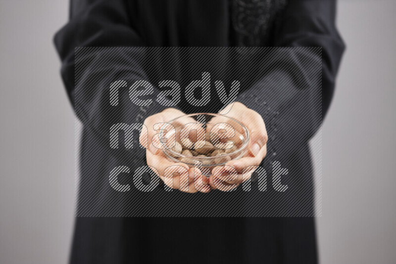 Woman in abaya holding different kinds of spices in different positions