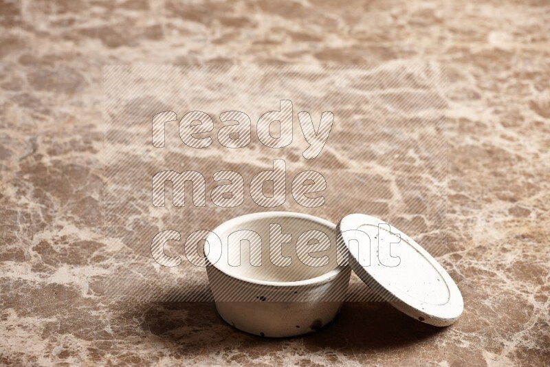 A white pottery bowl on beige marble background