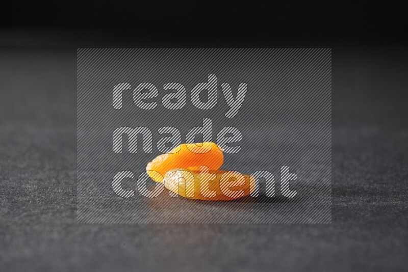 حبتان من المشمش المجفف على خلفية سوداء