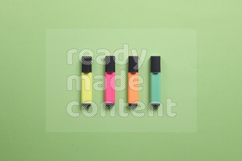 Multicolored highlighter pens on green background