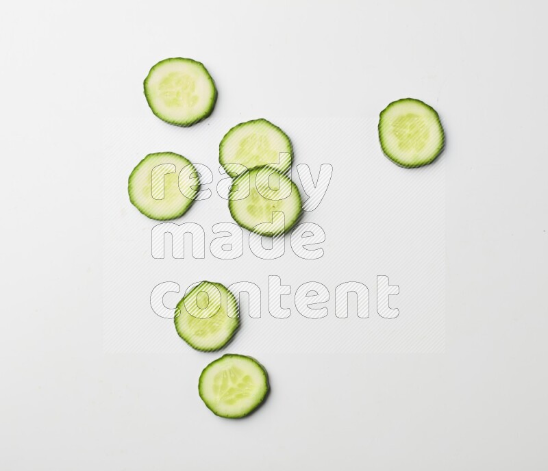 Multiple cucumber slices on white background