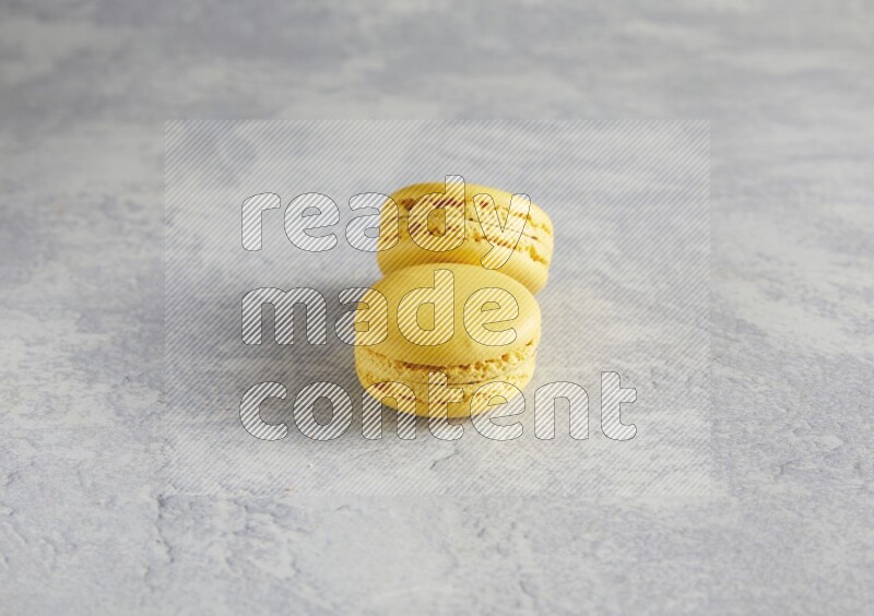 45º Shot of two Yellow Lemon macarons  on white  marble background