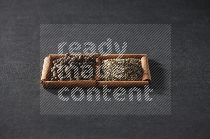 2 squares of cinnamon sticks full of cumin and allspice on black flooring