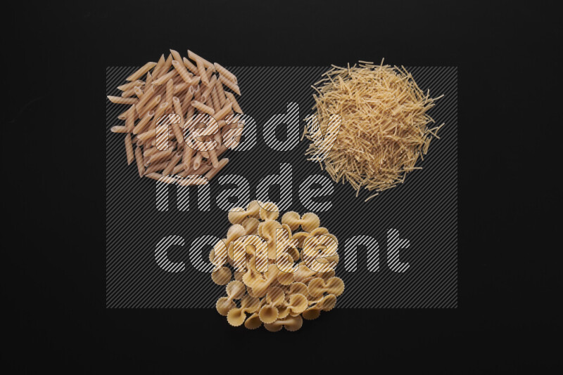 Different pasta types in bunches on black background