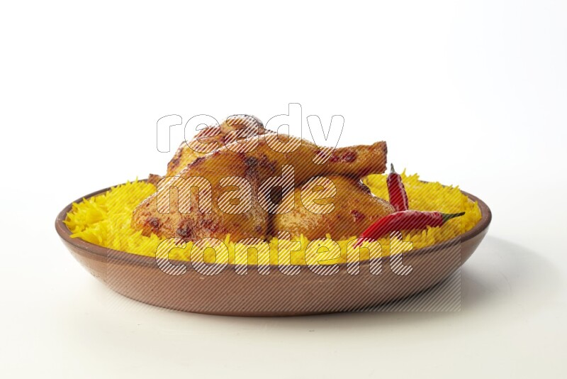 yellow basmati Rice with kabsa chicken pieces on a pottery plate direct on white background