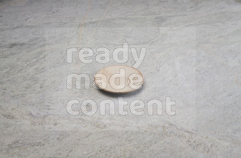 A beige pottery plate on grey marble background