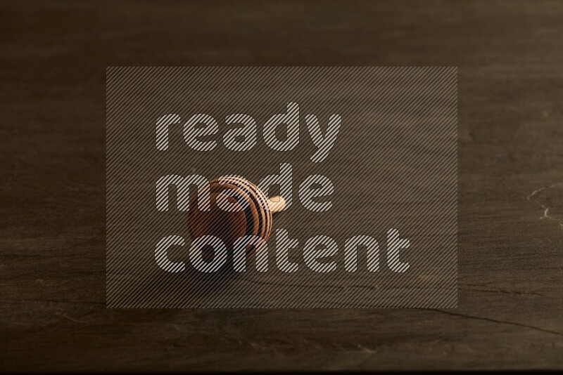 Wooden honey dipper on black slate background